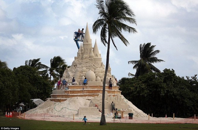 Опытные песка скульпторы работают, чтобы построить самый большой в мире замок из песка на пляже Вирджиния Ки, Флорида
