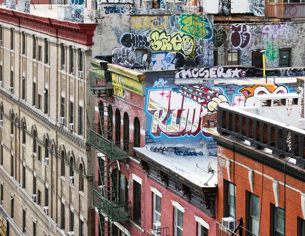 Недвижимость: New York City block of apartment buildings with graffiti covered roof tops