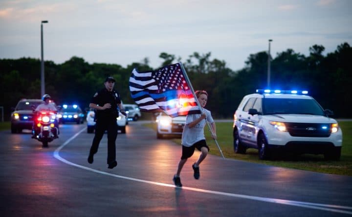 Локальные новости: Мальчик из Флориды с синим американским флагом в руках пробегает по миле в честь каждого погибшего офицера США