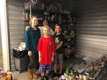 Локальные новости: фотография Мэттью с другими волонтерами в гараже, где они хранят продукты