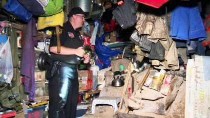 Закон и право: фотография полицейского, осматривающего вещи в бункере