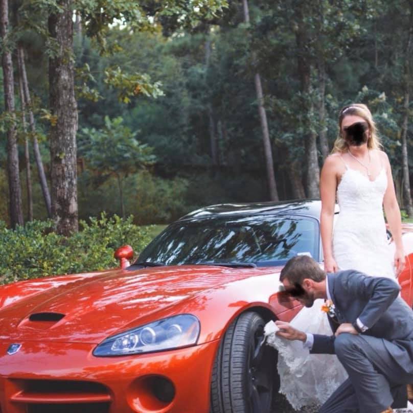 фотография жениха, протирающего колесо машины платьем невесты