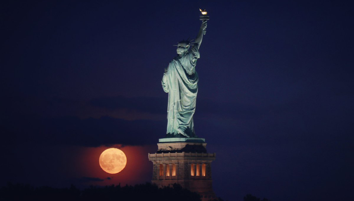 фотография урожайной луны над статуей Свободы