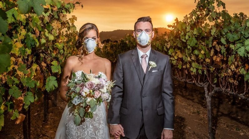 Досуг: «Отражение нового времени»: молодожены позируют для свадебного фото в масках во время бушующего в округе пожара