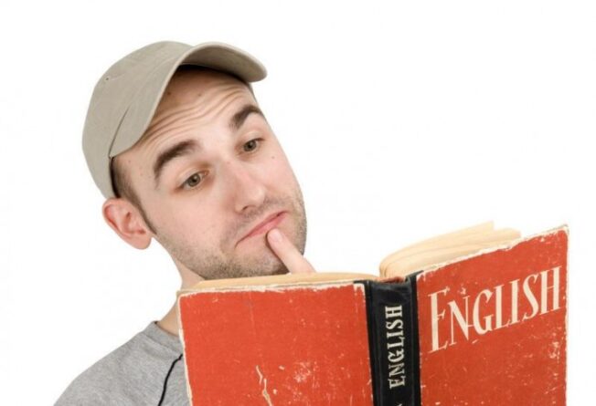 мужчина в кепке изучает учебник английского