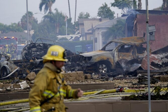 пожарный на фоне сгоревшего самолета и авто