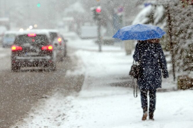 женщина под синим зонтом в снегопад