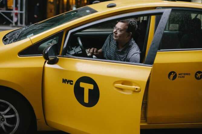 водитель в желтой машине такси